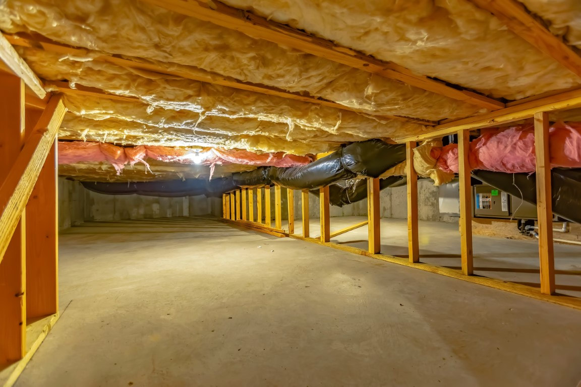 A basement with wooden beams and crawl space insulation